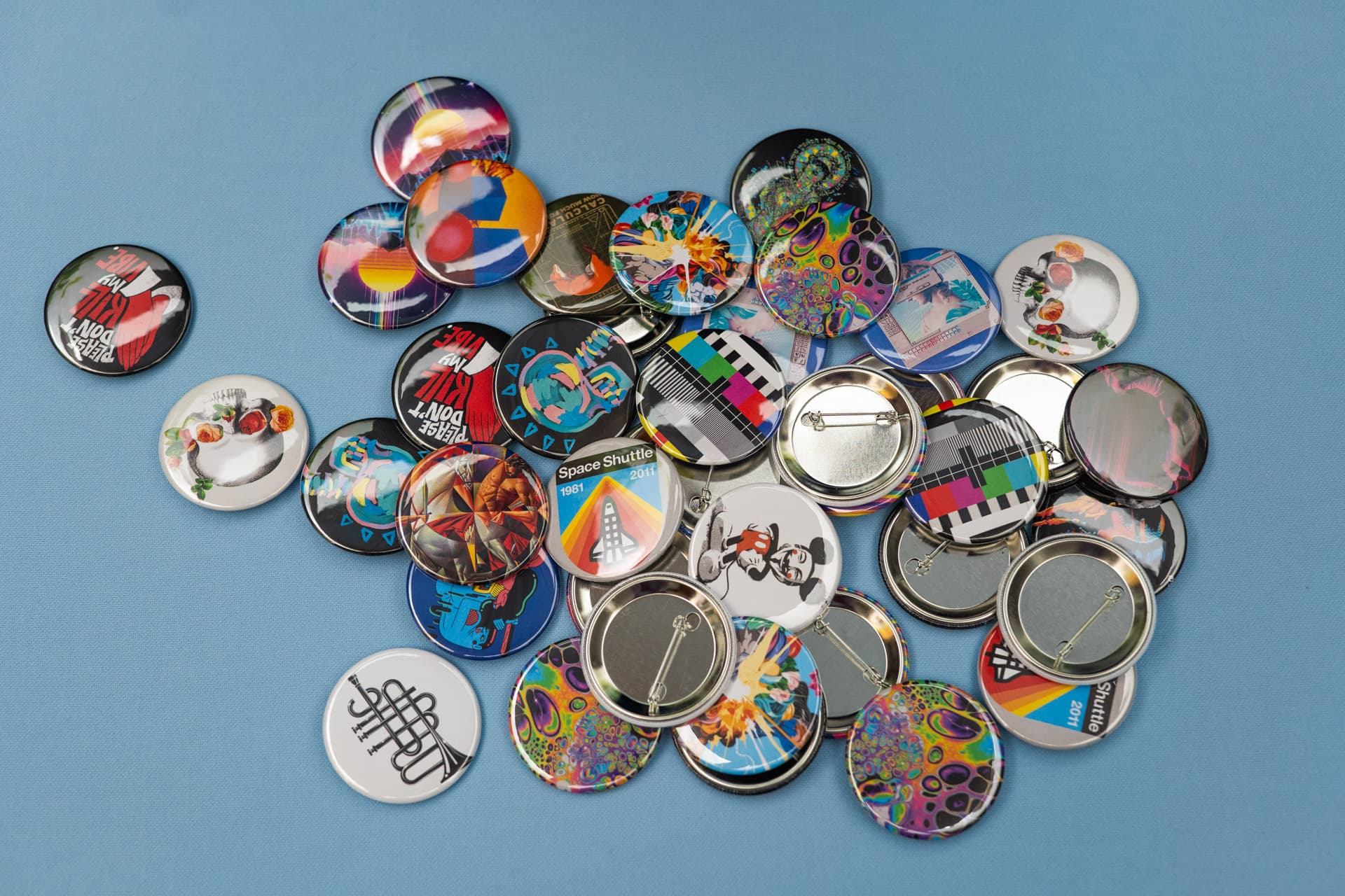 56mm custom button badges photographed on blue fabric